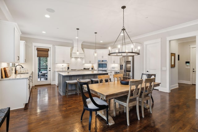 dining room with sink, crown molding, and dark hardwood / wood-style floors