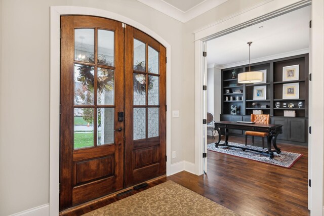 entrance foyer with crown molding, dark hardwood / wood-style floors, and french doors