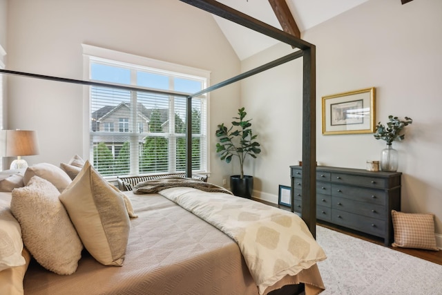 bedroom featuring beamed ceiling, wood-type flooring, and high vaulted ceiling