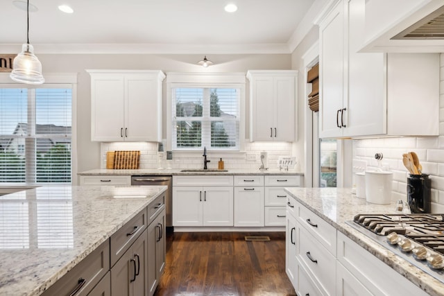 kitchen with sink, white cabinetry, decorative light fixtures, ornamental molding, and stainless steel gas stovetop