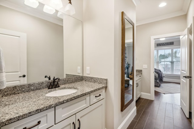 bathroom featuring ornamental molding, hardwood / wood-style floors, and vanity