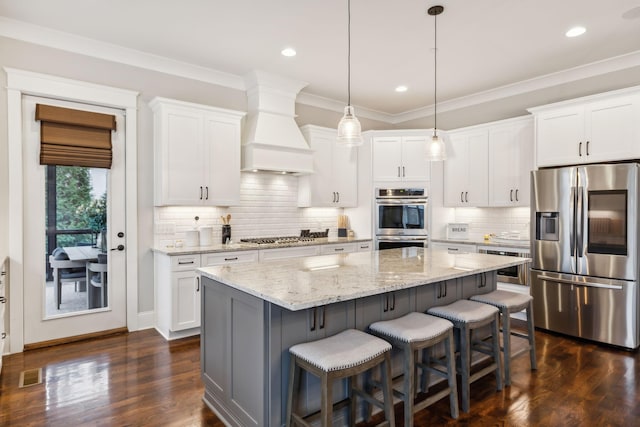 kitchen featuring white cabinetry, pendant lighting, a kitchen island, and appliances with stainless steel finishes