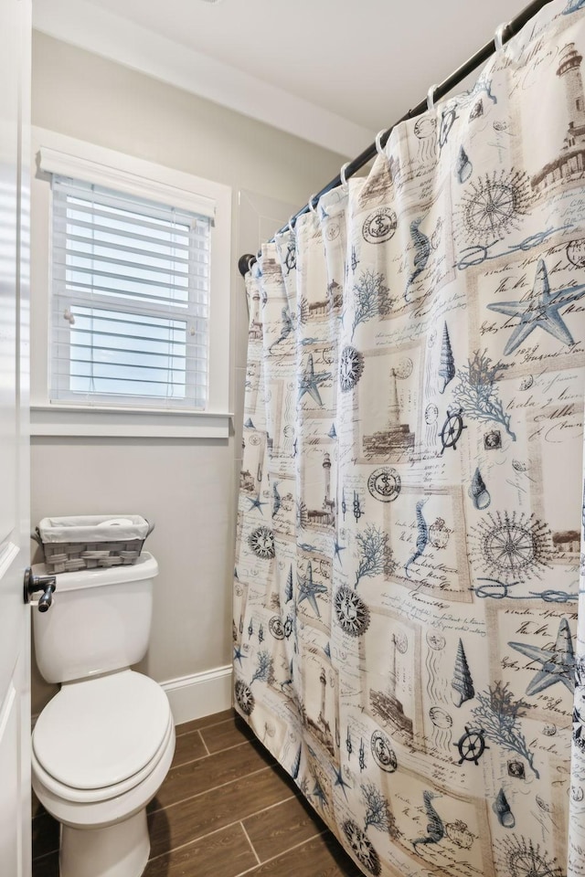 bathroom featuring toilet and curtained shower