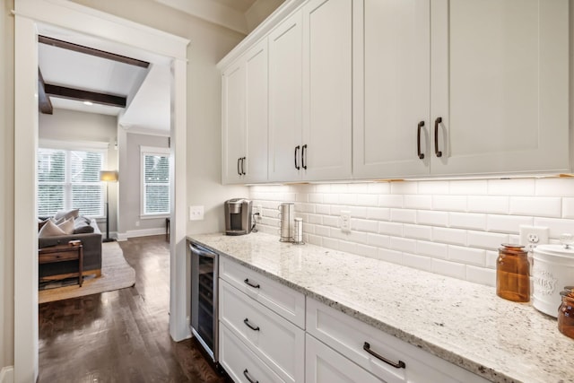 kitchen featuring tasteful backsplash, white cabinetry, beamed ceiling, beverage cooler, and light stone counters