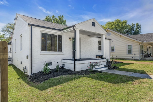 ranch-style home with covered porch and a front lawn