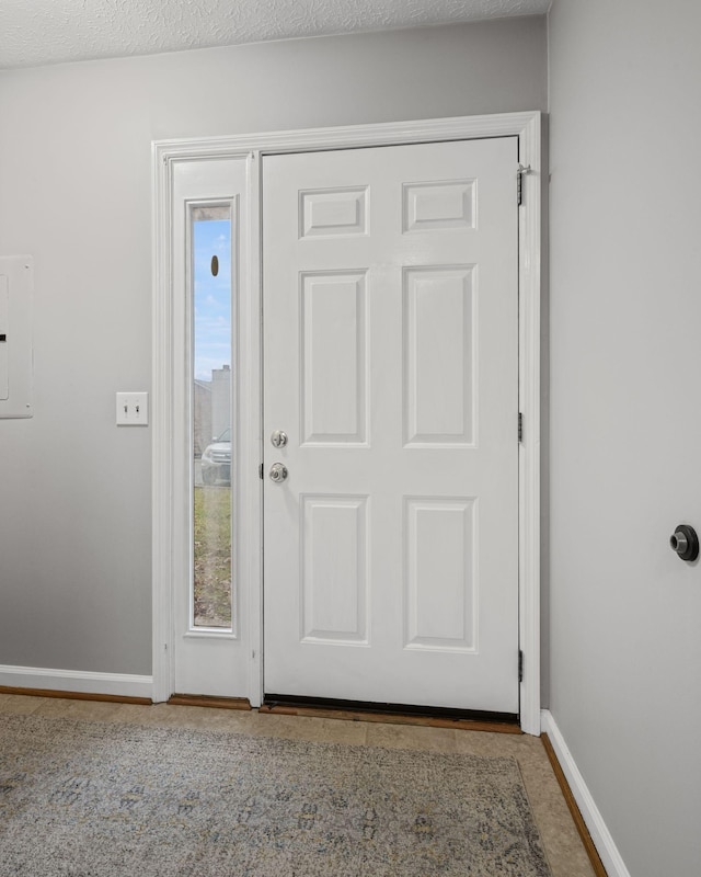 foyer entrance featuring plenty of natural light, electric panel, and a textured ceiling