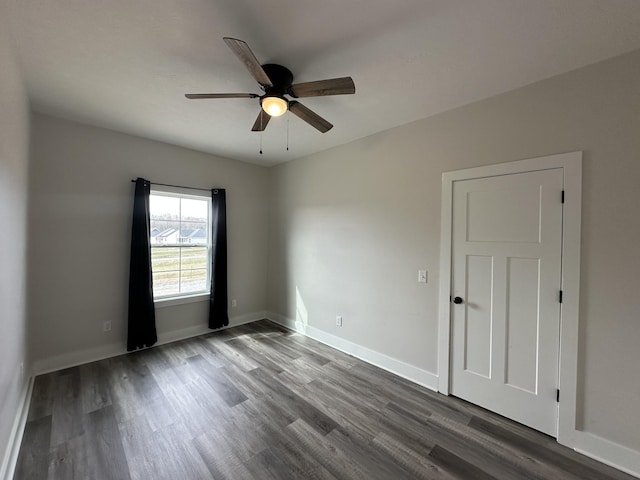 unfurnished room featuring wood finished floors, a ceiling fan, and baseboards