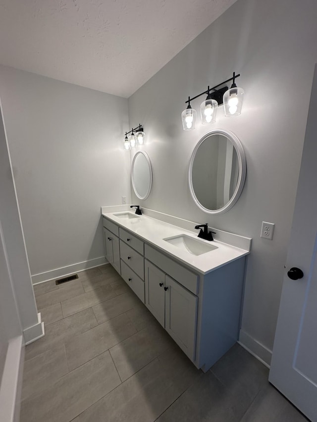 bathroom with double vanity, a sink, and baseboards