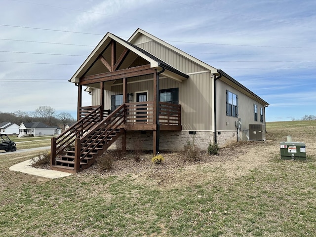 view of front of property featuring crawl space, covered porch, a front lawn, and central AC