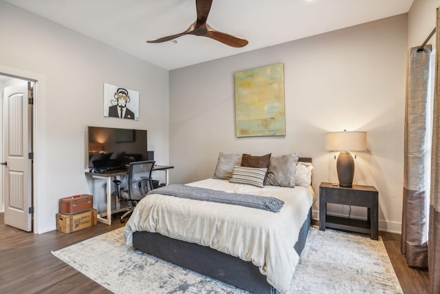 bedroom with baseboards, a ceiling fan, and dark wood-style flooring