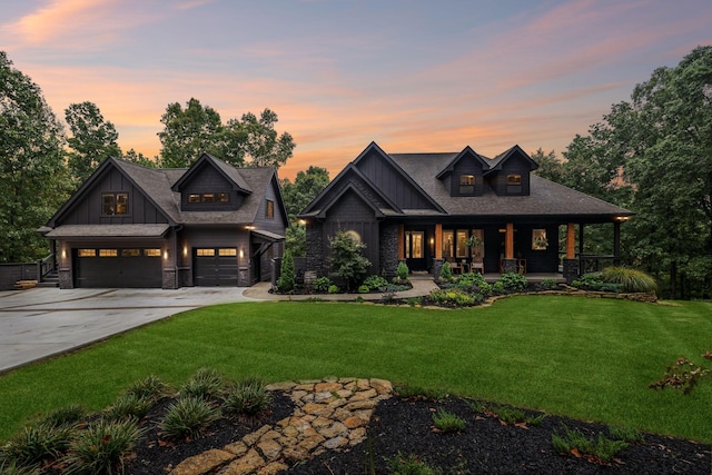 view of front of property featuring board and batten siding, covered porch, a lawn, and an attached garage