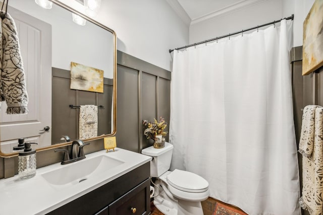 bathroom with toilet, vanity, and crown molding