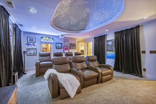 cinema featuring ornamental molding, a tray ceiling, light colored carpet, and visible vents