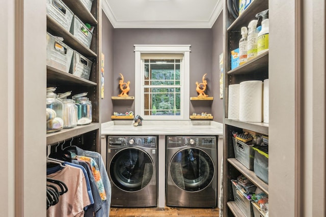 washroom with ornamental molding, washer and dryer, and laundry area