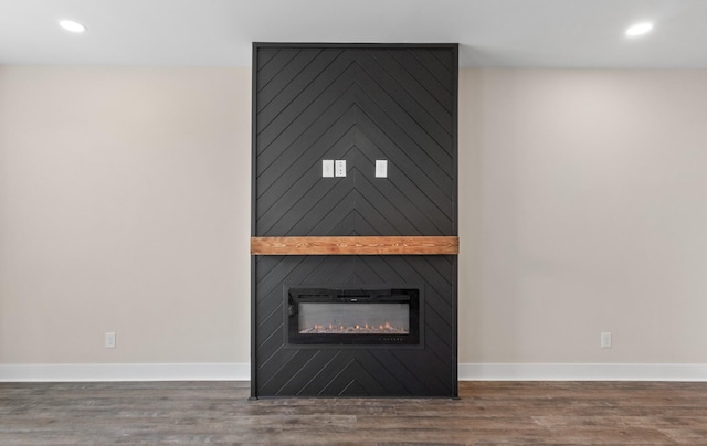 details featuring a fireplace, baseboards, and wood finished floors