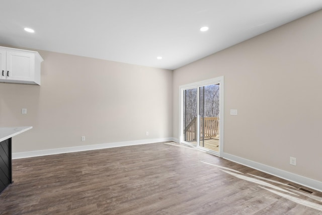 unfurnished living room featuring baseboards, visible vents, wood finished floors, and recessed lighting