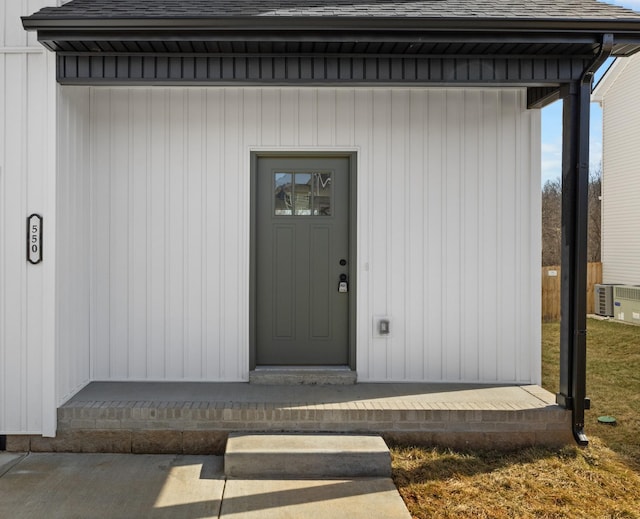 entrance to property featuring roof with shingles