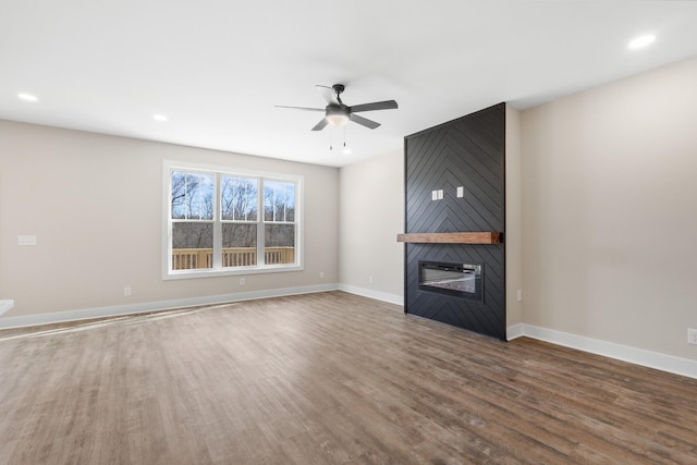 unfurnished living room featuring recessed lighting, a fireplace, wood finished floors, a ceiling fan, and baseboards