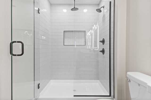 full bath featuring a stall shower and toilet