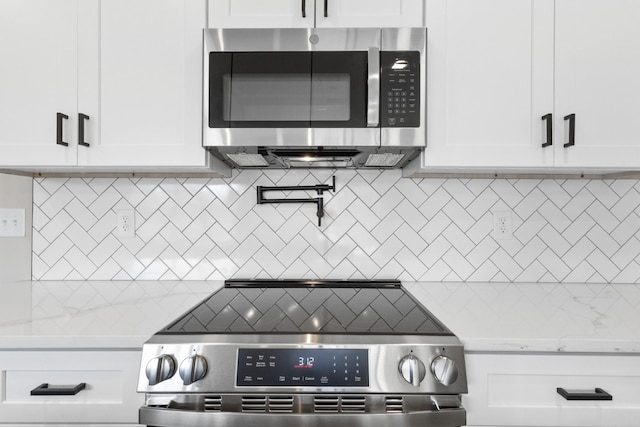 kitchen featuring stainless steel appliances, white cabinetry, and decorative backsplash