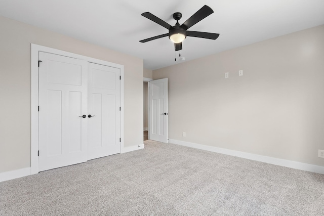 unfurnished bedroom with ceiling fan, a closet, carpet flooring, and baseboards