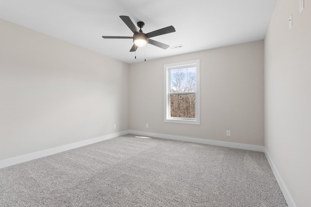 carpeted empty room with visible vents, ceiling fan, and baseboards