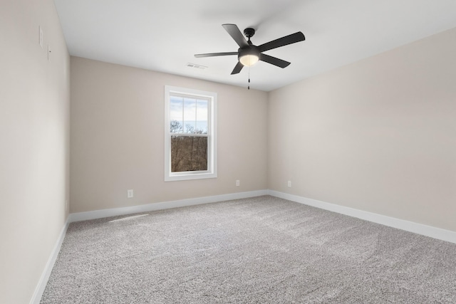 unfurnished room with carpet, visible vents, ceiling fan, and baseboards