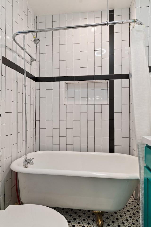 bathroom featuring toilet, tile walls, and a tub