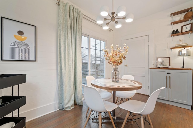 dining space with dark wood-type flooring and a notable chandelier