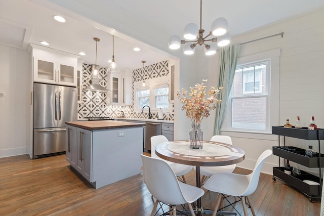 dining space with sink, dark hardwood / wood-style floors, and a chandelier