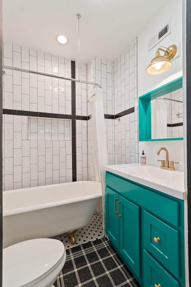 bathroom featuring vanity, tile walls, tile patterned floors, and toilet