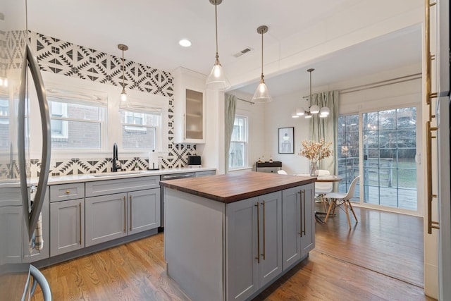 kitchen with pendant lighting, a center island, sink, and gray cabinetry