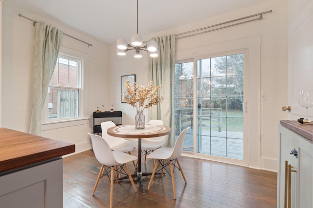 dining room with dark hardwood / wood-style flooring, plenty of natural light, and a chandelier