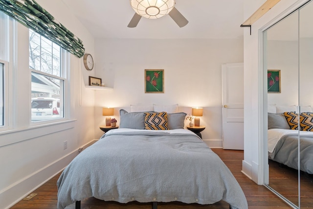 bedroom with dark hardwood / wood-style floors, ceiling fan, and a closet