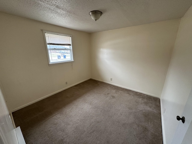 carpeted empty room featuring a textured ceiling