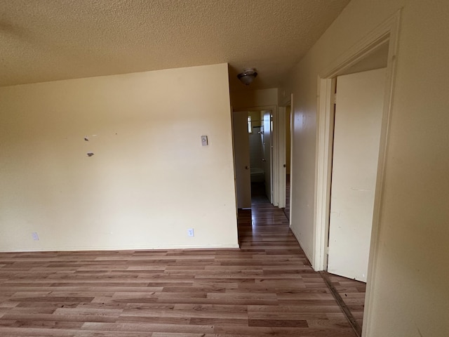 hall featuring light hardwood / wood-style floors and a textured ceiling