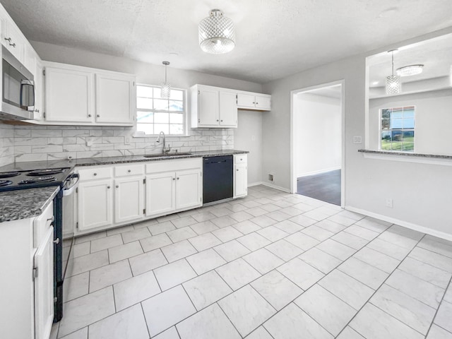 kitchen featuring black dishwasher, pendant lighting, and white cabinets