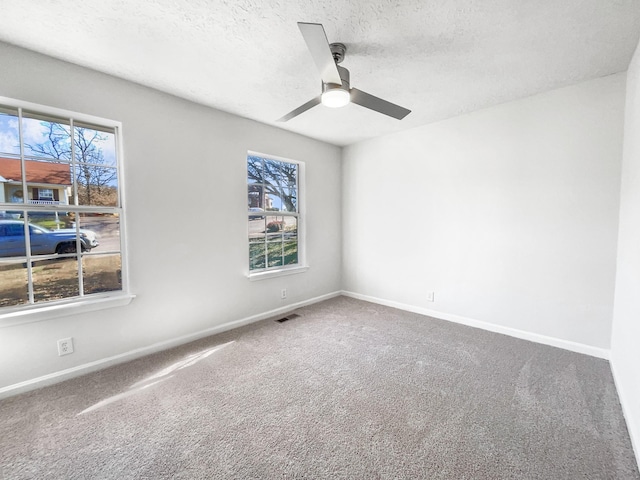 carpeted empty room featuring ceiling fan and a textured ceiling