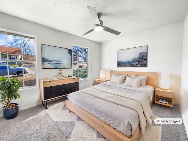 carpeted bedroom with ceiling fan and a textured ceiling