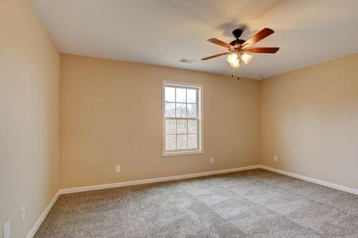 unfurnished room with light colored carpet and ceiling fan