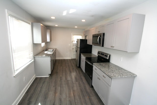 kitchen with stainless steel appliances, a wealth of natural light, and white cabinets