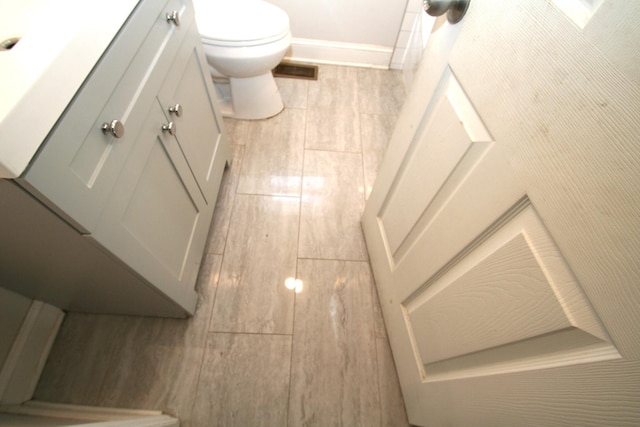 bathroom featuring toilet, wood tiled floor, visible vents, and vanity