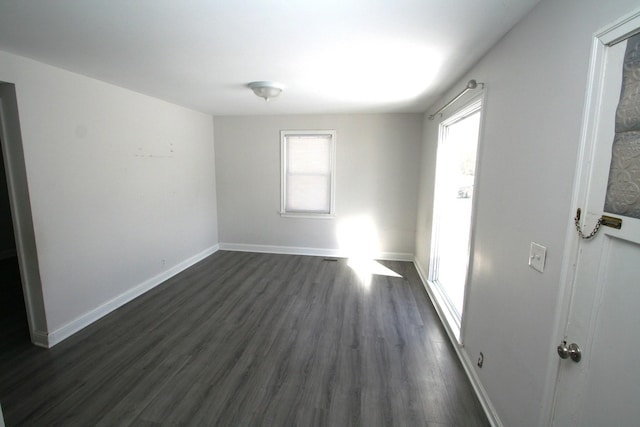 spare room with dark wood finished floors and baseboards