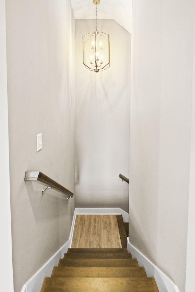 staircase featuring hardwood / wood-style floors and a chandelier