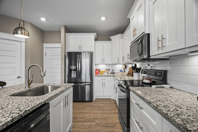 kitchen with white cabinetry, sink, pendant lighting, and black appliances