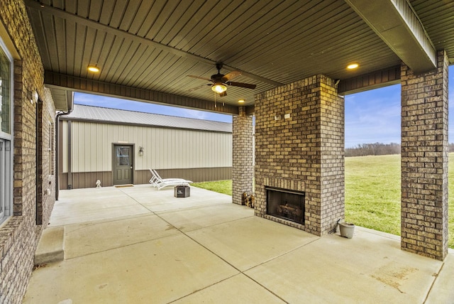 view of patio / terrace featuring an outdoor brick fireplace and ceiling fan