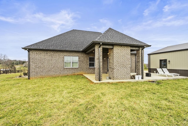 rear view of house featuring a yard and a patio