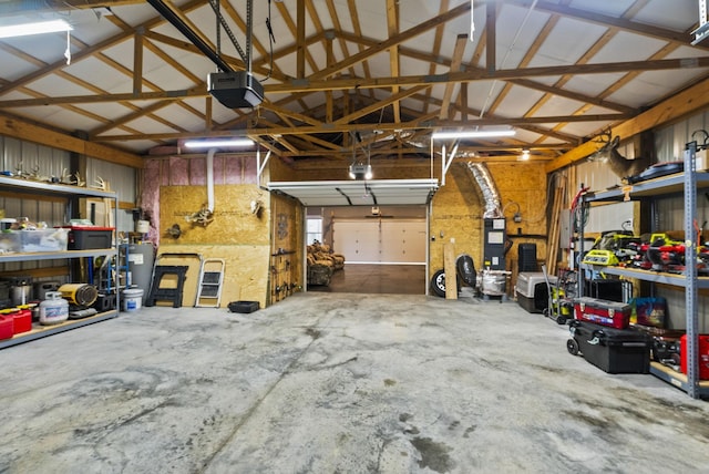 garage featuring a garage door opener, a workshop area, and water heater