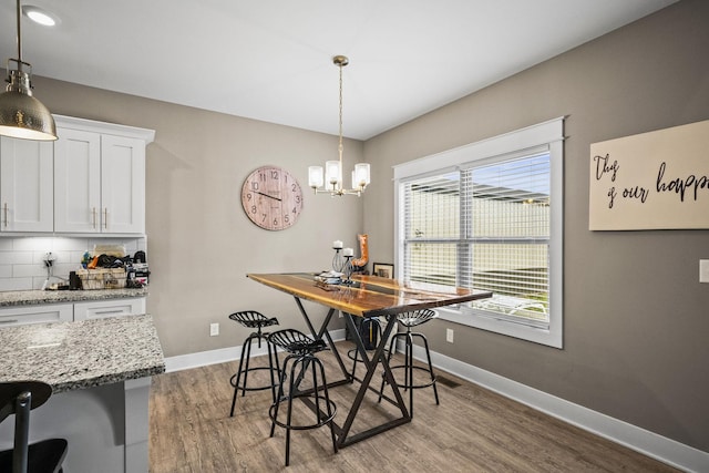 dining room with light hardwood / wood-style flooring and a notable chandelier