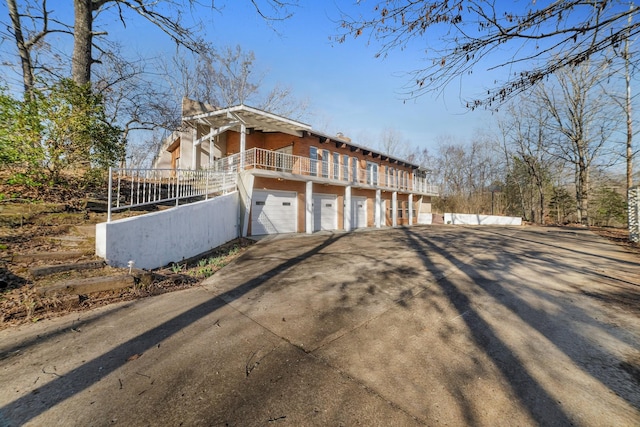 view of side of home featuring driveway, a chimney, and fence